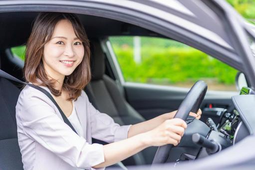 安全運転をこころがけて笑顔でハンドルを握り安全運転をしている女性ドライバー