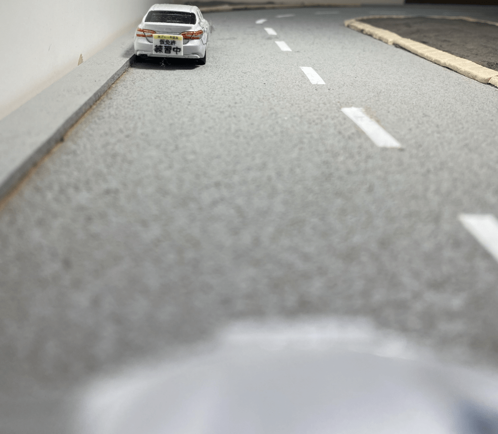 自動車教習所の外周コースに教習車が止まっている。