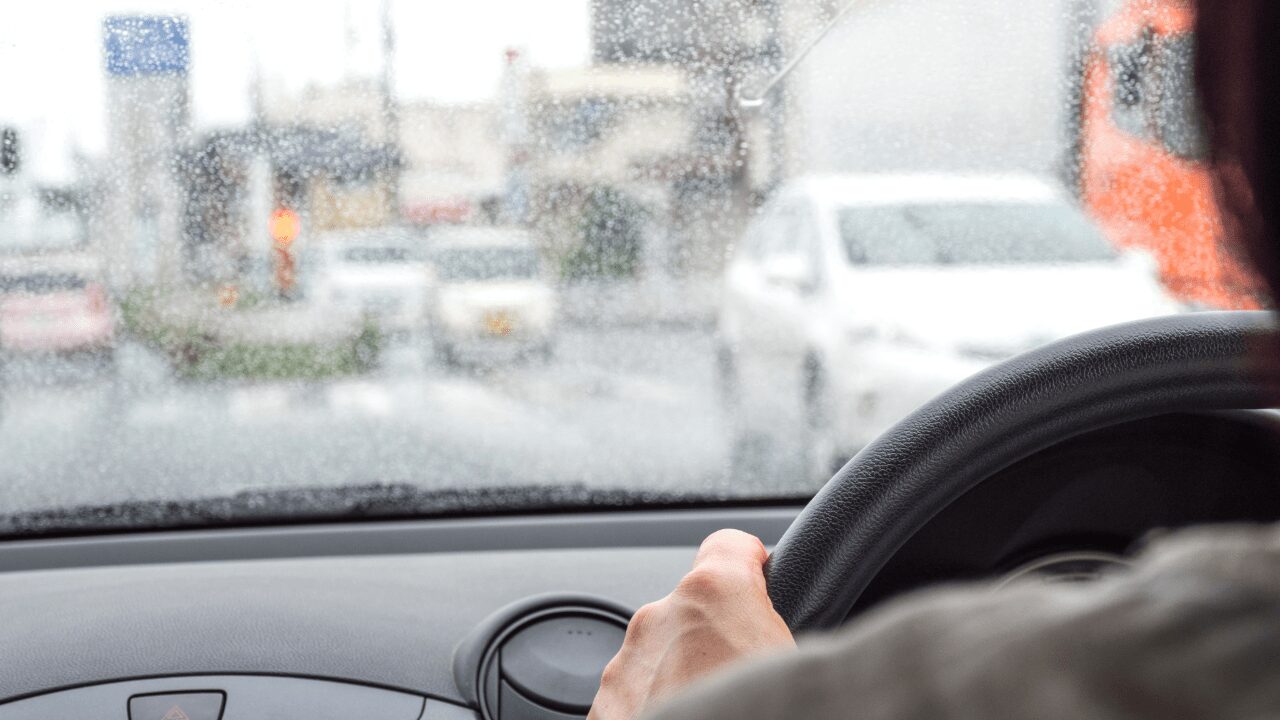 雨の日に運転している初心者ドライバーが交差点で右折待ちをしている
