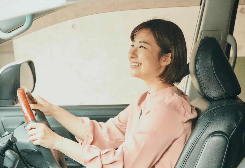 安全な運転をして笑顔な女性ドライバー
