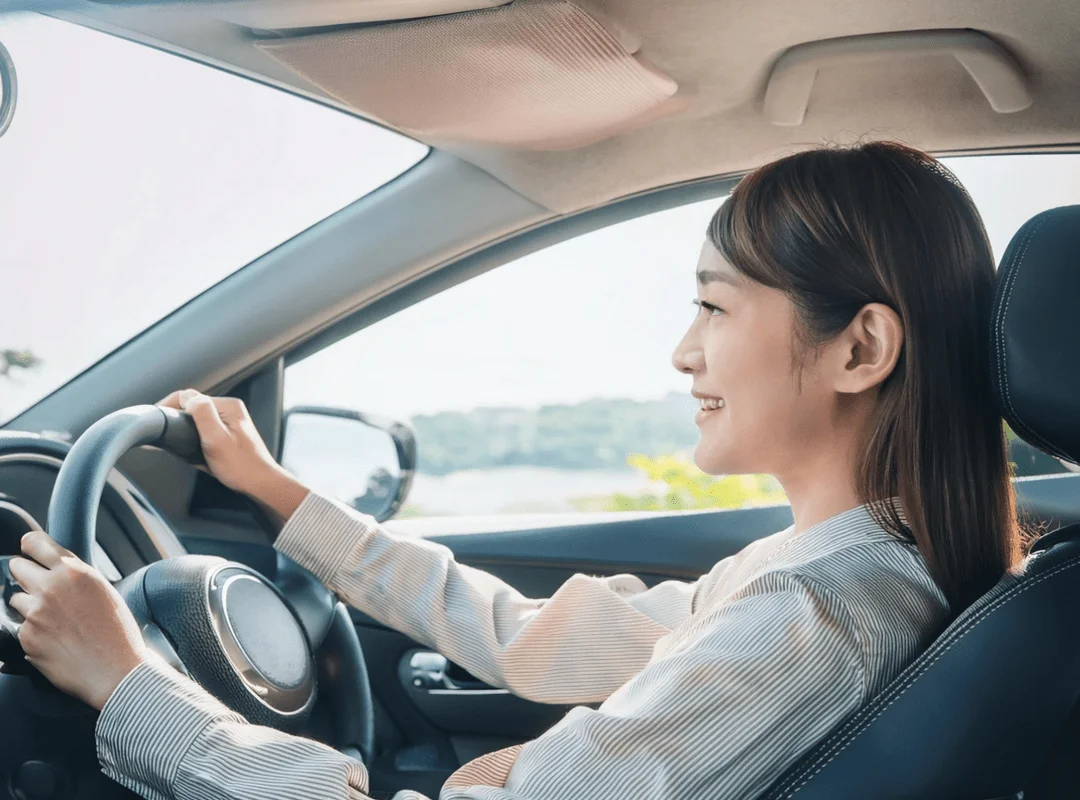 運転が怖くて仕方なかったが、遠くを見ることで笑顔で運転している女性の初心者ドライバー