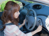 車のエンジンをかけようとしている女性ドライバー